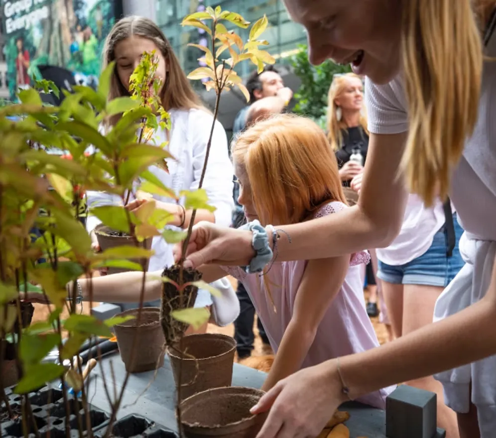 Visitors participate in a tree-planting activity at a Facebook Groups activation, engaging hands-on with saplings and community-focused environmental initiatives.